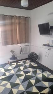 a bedroom with a checkered floor with a window and a television at Panga Loft in Abraão