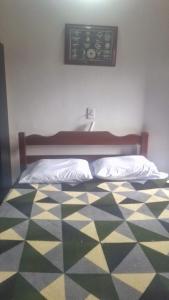 a bedroom with a bed with a checkered floor at Panga Loft in Abraão