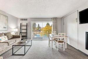 een woonkamer met een bank en een tafel bij Second-floor - Riverfront Condo Near Downtown Bend in Bend