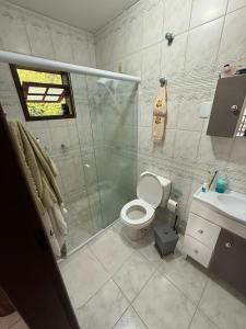 a bathroom with a shower and a toilet and a sink at Interior beach house in Bombinhas! in Bombinhas