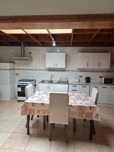 eine Küche mit einem Tisch mit Stühlen und einem Waschbecken in der Unterkunft M&M Hospedaje in Calama