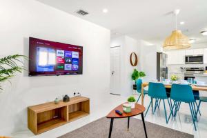 a kitchen and dining room with a tv on the wall at Prime Location Duplex with Free Parking in Miami