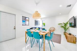 a dining room with a wooden table and blue chairs at Prime Location Duplex with Free Parking in Miami