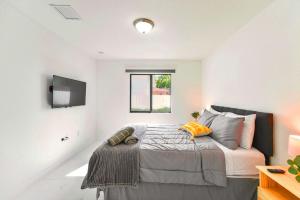 a bedroom with a bed and a tv on the wall at Prime Location Duplex with Free Parking in Miami