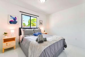 a bedroom with a large bed and a window at Prime Location Duplex with Free Parking in Miami