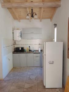 eine Küche mit weißen Schränken und einem weißen Kühlschrank in der Unterkunft Tacuarita in Los Hornillos