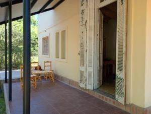 eine offene Tür zu einer Terrasse mit Tisch und Stühlen in der Unterkunft Tacuarita in Los Hornillos + 14 Fotos