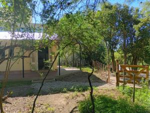 a garden with a wooden bench in front of a building at Tacuarita in Los Hornillos