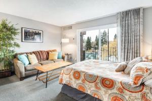 ein Schlafzimmer mit einem großen Bett und einer Couch in der Unterkunft River View Condo- Edge of Downtown in Bend