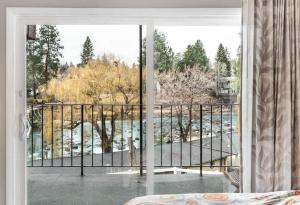 Schlafzimmer mit Balkon und Blick auf das Wasser in der Unterkunft River View Condo- Edge of Downtown in Bend