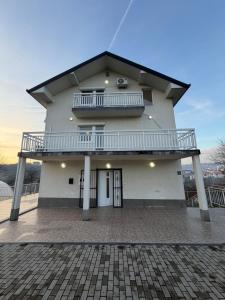a white house with a balcony on top of it at White Villa Blažuj in Blažuj
