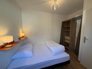 een slaapkamer met een bed met 2 kussens en een lamp bij T2 Dream in Périgueux