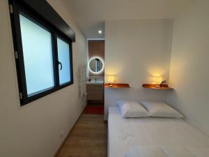 een kamer met een bed, een raam en een spiegel bij T2 Dream in Périgueux