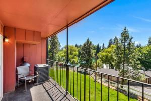 einen Balkon mit einem Stuhl und Blick auf einen Hof in der Unterkunft Riverfront Condo - Pet Friendly Near Downtown in Bend