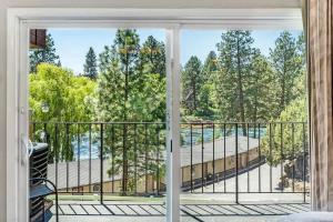 einen Balkon mit Blick auf den Pool und die Bäume in der Unterkunft Riverfront Condo - Pet Friendly Near Downtown in Bend