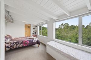 a bedroom with a bed and large windows at The Wee Glen - Peaceful Country Retreat 2 bed in Bennetts
