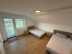 a small room with two beds and a window at White Villa Blažuj in Blažuj