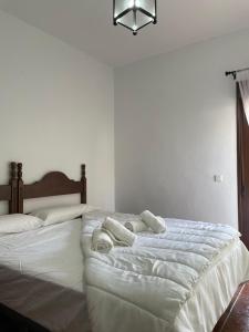 ein Schlafzimmer mit einem großen weißen Bett mit Handtüchern darauf in der Unterkunft Hotel Restaurante Atalaya in Comares + 18 Fotos