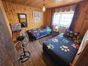 a small room with two beds and a window at Hostal Sol y Luna - Descanso a 10 min del aeropuerto & Desayuno Incluido in Santiago