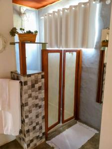 un bagno con 2 specchi e una doccia di Studio Gaya a Palmeiras