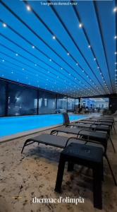 een rij ligstoelen in een zwembad 's nachts bij Thermae D'Olimpia & SPA - Adults Only 14 Plus in Băile Herculane