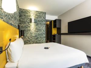 ein Hotelzimmer mit Bett und Flachbildfernseher in der Unterkunft ibis Styles Puteaux Paris La Defense in Puteaux