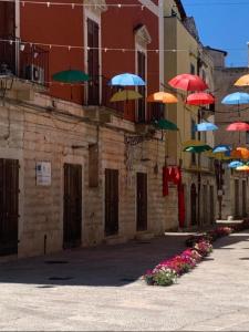 een groep kleurrijke paraplu's die boven een gebouw hangen bij Laura stone room in Corato