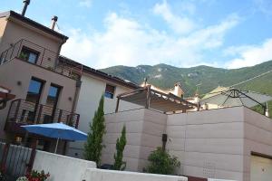 a house with a fence and an umbrella at La Salvia e Il Lampone in Pove del Grappa