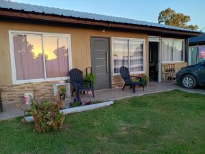 una casa con due sedie in cortile di Laila y León a General Juan Madariaga