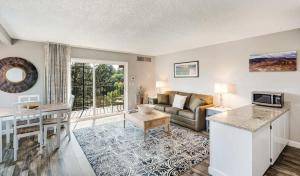 ein Wohnzimmer mit Sofa und Tisch in der Unterkunft Riverfront Condo with Amazing View - Downtown Bend in Bend