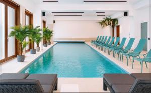 a pool in a room with chairs and tables at Hotel&SPA 5 HILLS DRAGASANI in Drăgăşani