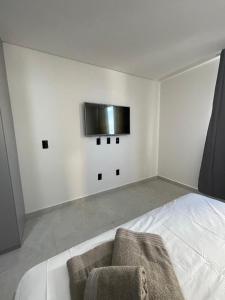 een slaapkamer met een bed en een tv aan de muur bij Flat em Intermares Beach in Cabedelo