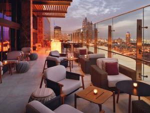 a rooftop bar with chairs and tables on a building at Grand Plaza Mövenpick Media City in Dubai