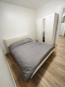 Bett in einem weißen Zimmer mit Spiegel in der Unterkunft Renovated prestige apartment in Aubervilliers
