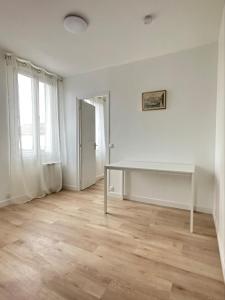 ein leeres weißes Zimmer mit einem Tisch und einem Fenster in der Unterkunft Renovated prestige apartment in Aubervilliers