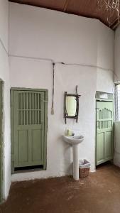 un bagno con un lavandino e due porte verdi di Casa ANKAA a Flores