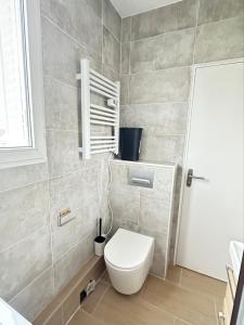 ein Bad mit einem WC und einer weißen Tür in der Unterkunft Renovated prestige apartment in Aubervilliers