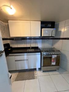 una piccola cucina con piano cottura e forno a microonde di Apto Recife Aurora Mar e Rio a Recife