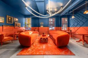 a living room with orange chairs and a red rug at Symons Block Suite 5 in Spokane