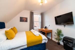 a bedroom with a bed and a flat screen tv at The Linden Leaf Rooms with free car parking in Nottingham