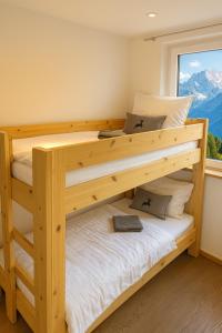 1 Schlafzimmer mit 2 Etagenbetten und einem Fenster in der Unterkunft Haus Dienten Appartements am Hochkoenig in Dienten am Hochkönig