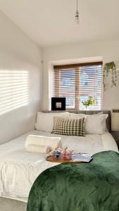 a bedroom with a large bed with a tray on it at Modern 2-Bed Flat, Spacious, near Harry Potter Studio in Watford