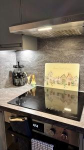 a sign on a stove top in a kitchen at Modern 2-Bed Flat, Spacious, near Harry Potter Studio in Watford +16 photos