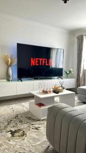 a living room with a television on a white entertainment center at Modern 2-Bed Flat, Spacious, near Harry Potter Studio in Watford