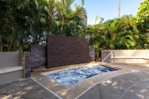 a plunge pool in a backyard with palm trees at Peaceful condo with lanai & beach essentials in Waikoloa