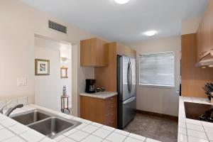 a kitchen with a sink and a refrigerator at Peaceful condo with lanai & beach essentials in Waikoloa