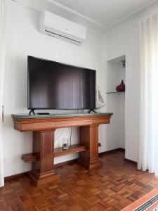 ein Flachbildfernseher auf einem Ständer in einem Raum in der Unterkunft Flipflops Ocean View in Nazaré