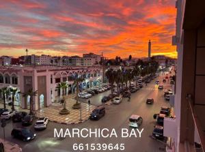 een stadsstraat met auto's geparkeerd op een parkeerplaats bij Marchica bay 8 holiday Apartment in Nador