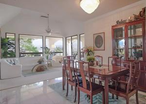 a living room with a wooden table and chairs at Golf-view condo with golf discounts & lanai in Waikoloa +9 photos