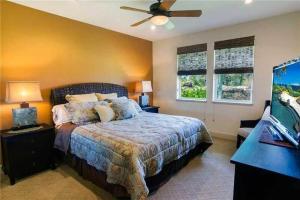 a bedroom with a bed and a ceiling fan at Waikoloa condo with golf & ocean views in Waikoloa
